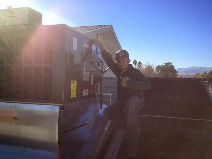 HVAC technician performing AC Tune-Up on a rooftop unit in Northbridge
